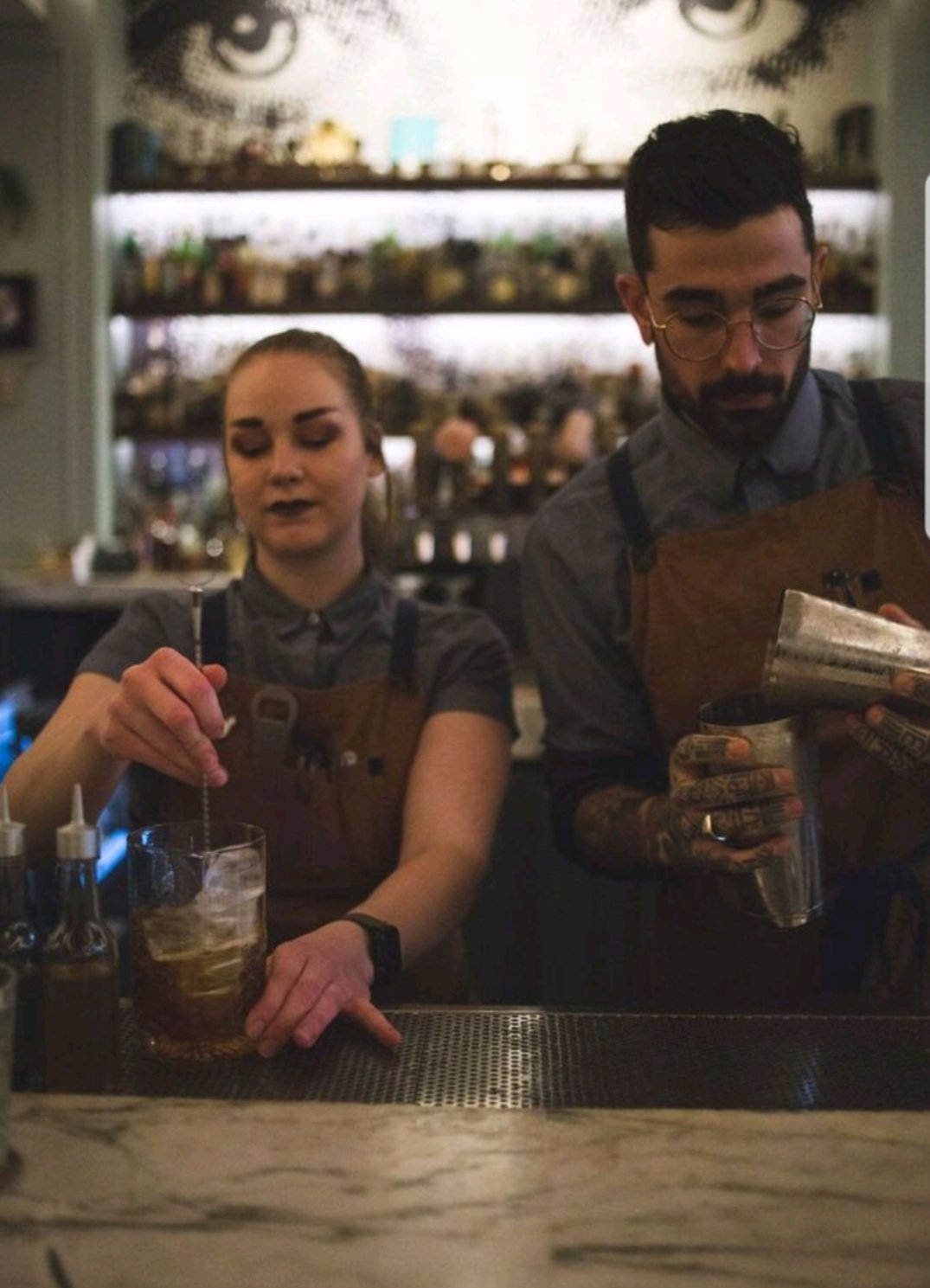 Bartender smiling with team behind bar during a busy service in Nashville: Expressing Gratitude