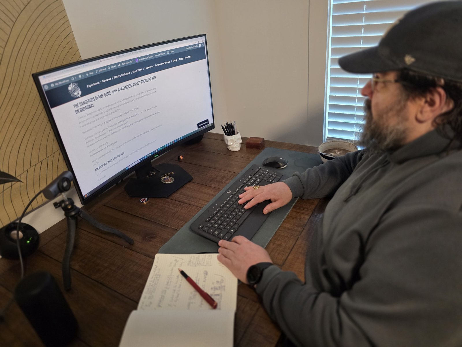 Reviewing Hospitality Editorial Work Writing at a desk reviewing a hospitality industry editorial on a large monitor, with notes open beside the keyboard.
